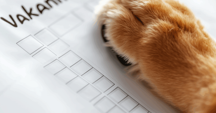 Hondenpoot op checklist met het woord ‘Vakantie’, symbool voor voorbereiding op vakantie met de hond.